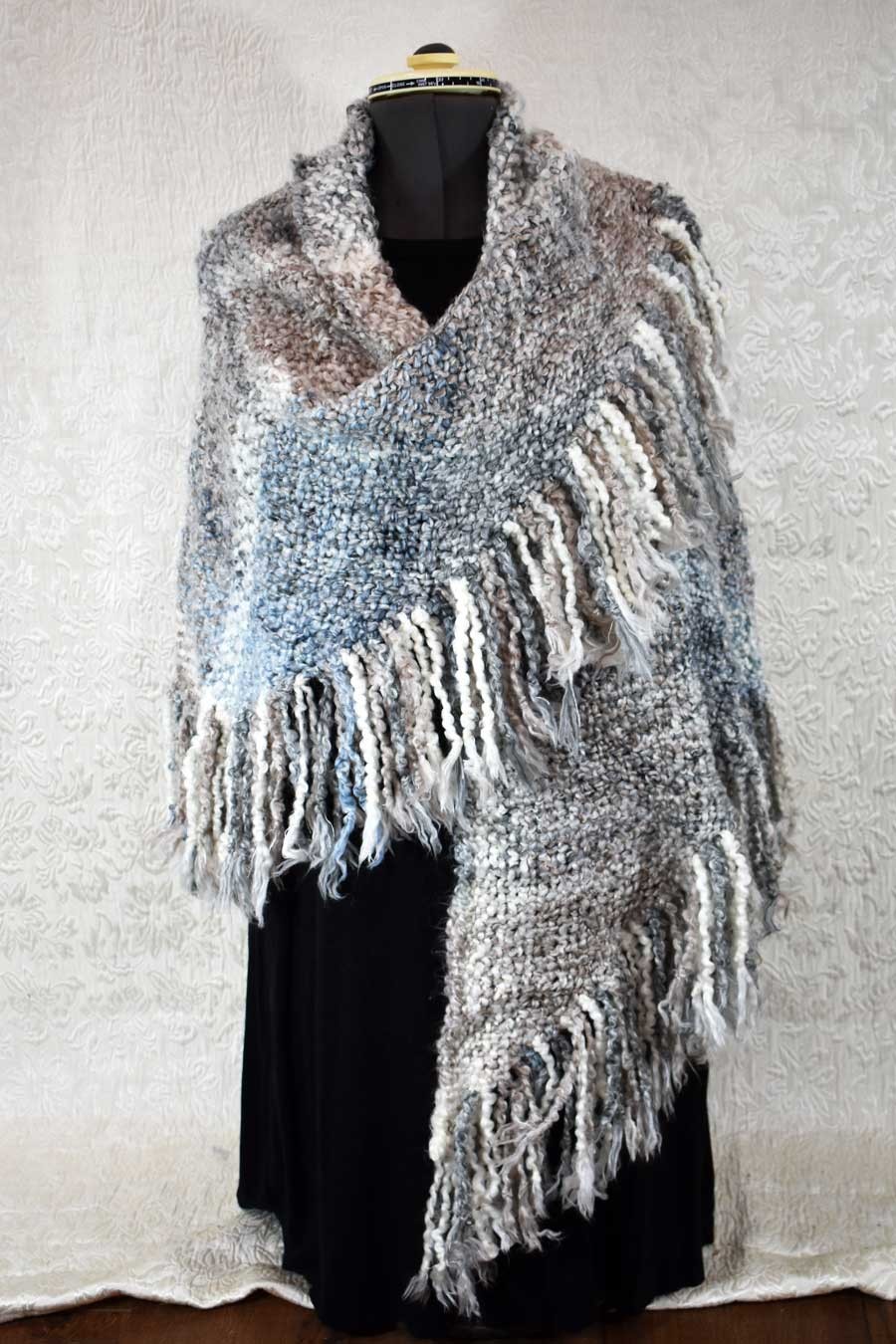 Handwoven triangular shawl in muted blue, tan, and cream