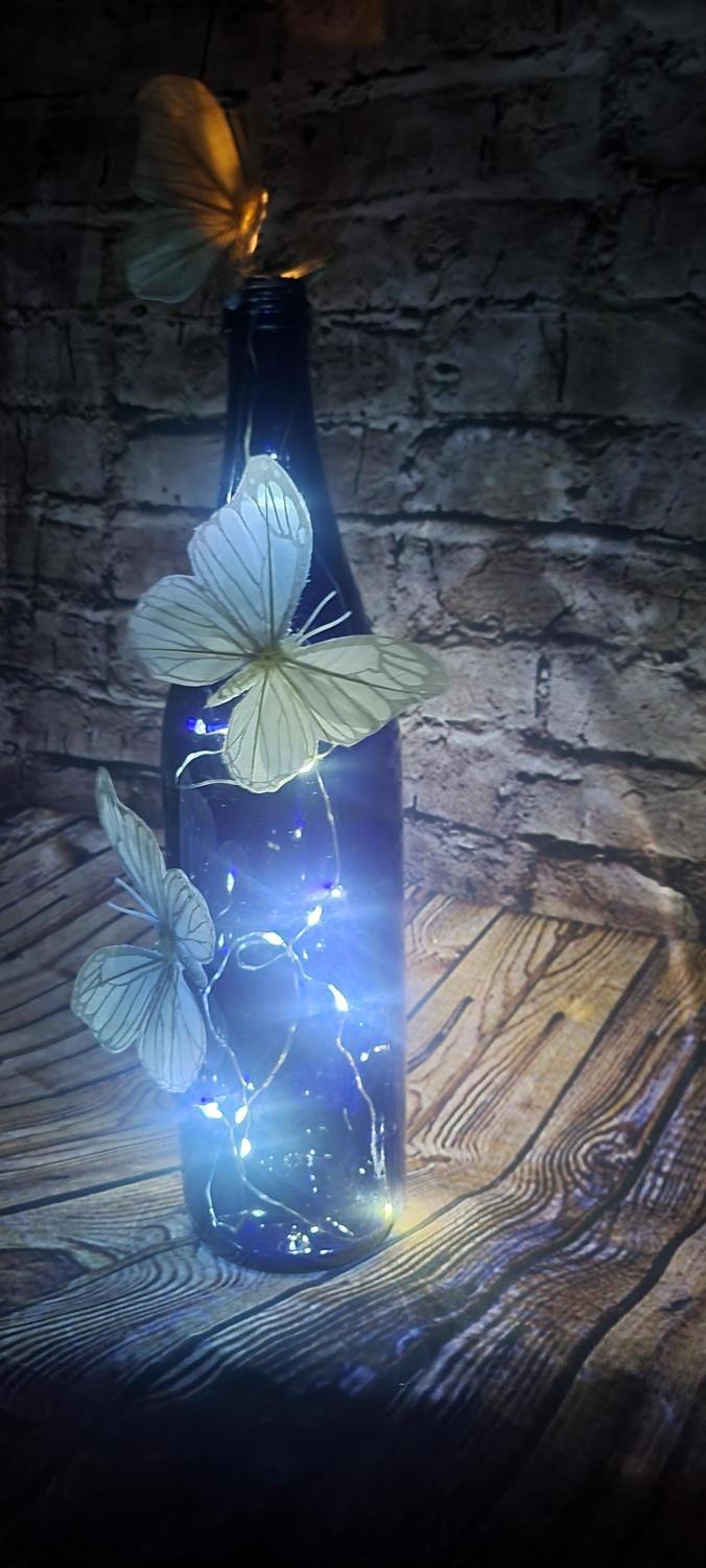 Cobalt blue wine bottle electric LED lights with white butterflies table decor centerpiece